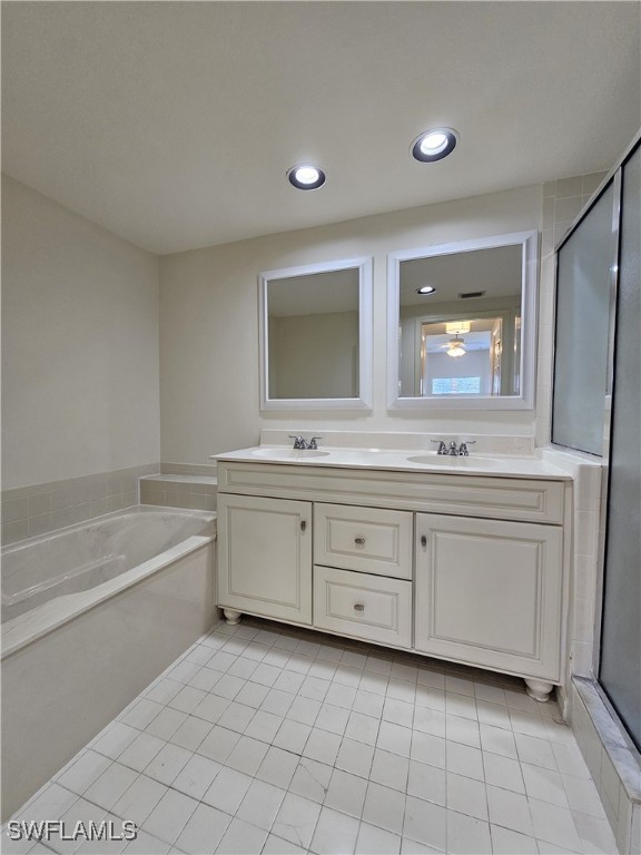 6025 Chardonnay Ln Unit 102, Naples, FL 34119 - full bath featuring double vanity, a garden tub, a stall shower, tile patterned floors, and recessed lighting