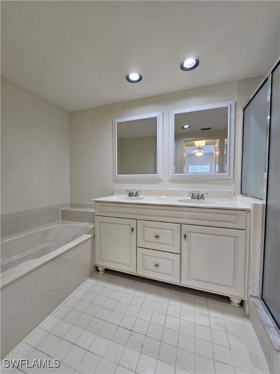 6025 Chardonnay Ln Unit 102, Naples, FL 34119 - full bath with double vanity, a garden tub, tile patterned flooring, recessed lighting, and an enclosed shower