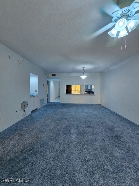 6025 Chardonnay Ln Unit 102, Naples, FL 34119 - unfurnished living room with carpet floors, a ceiling fan, and a textured ceiling