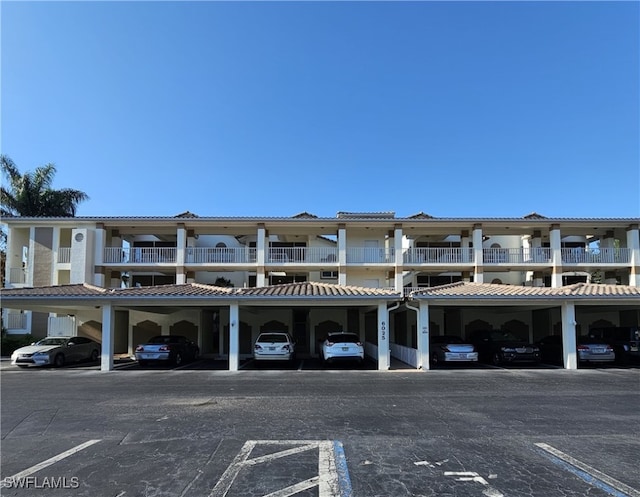 6025 Chardonnay Ln Unit 102, Naples, FL 34119 - view of building exterior featuring covered and uncovered parking