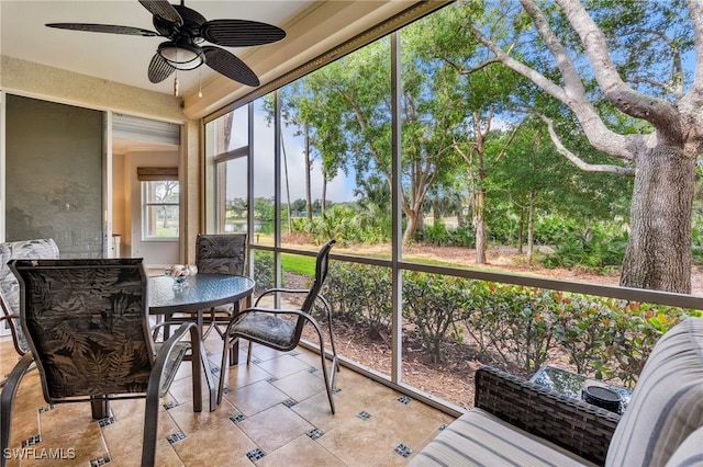sunroom with ceiling fan and outdoor dining space