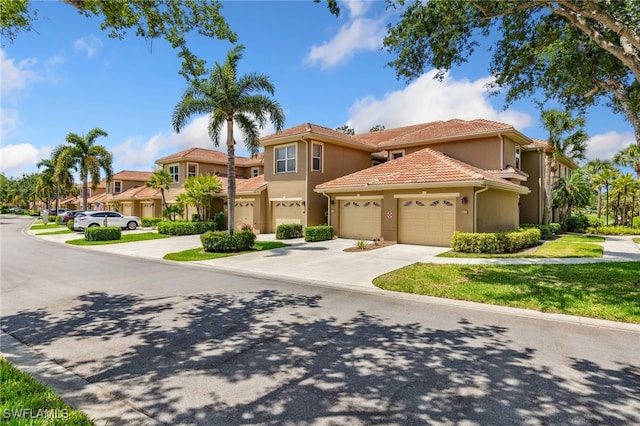mediterranean / spanish-style home with an attached garage, stucco siding, and driveway