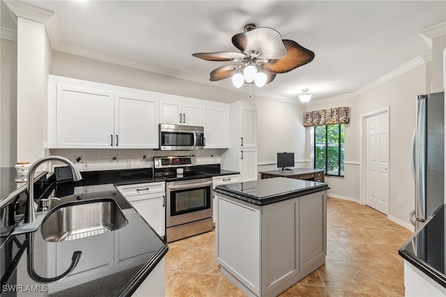 kitchen featuring a ceiling fan, a center island, a sink, ornamental molding, and stainless steel appliances