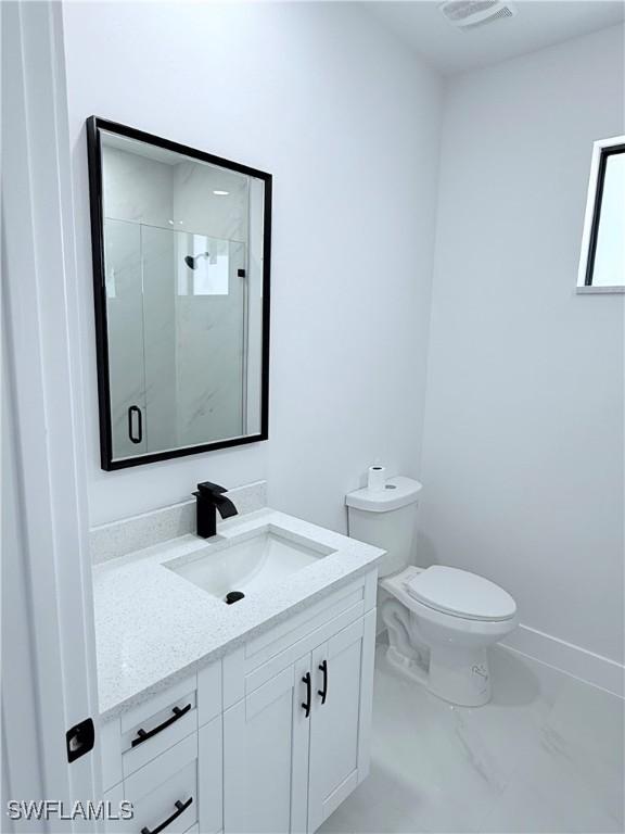 512 Genesee Ave S, Lehigh Acres, FL 33974 - bathroom featuring vanity, marble finish flooring, toilet, a stall shower, and baseboards