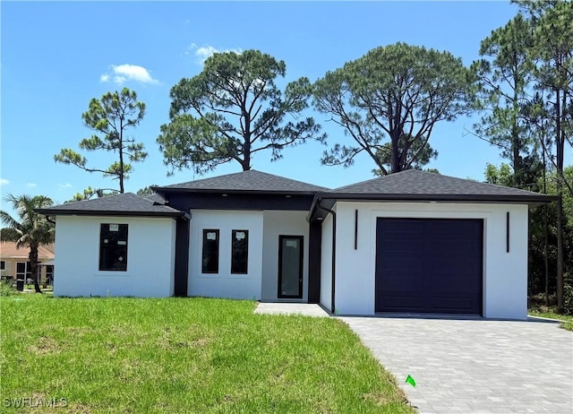 512 Genesee Ave S, Lehigh Acres, FL 33974 - prairie-style home featuring an attached garage, stucco siding, a front lawn, and decorative driveway