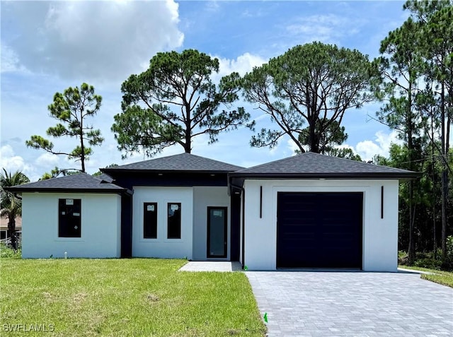 512 Genesee Ave S, Lehigh Acres, FL 33974 - prairie-style house featuring a garage, a front lawn, stucco siding, and decorative driveway