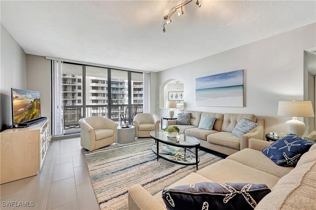 living area with a wall of windows and arched walkways
