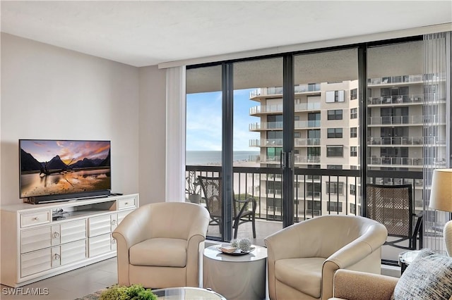 living area featuring a water view and a wall of windows