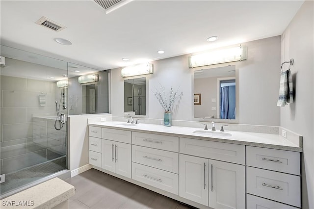 full bathroom with double vanity, visible vents, a stall shower, a sink, and recessed lighting