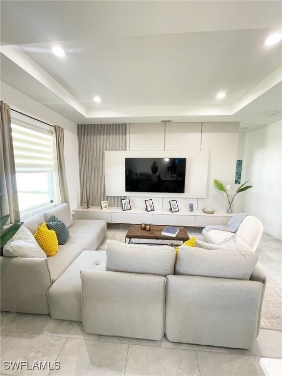 living area with a tray ceiling and recessed lighting