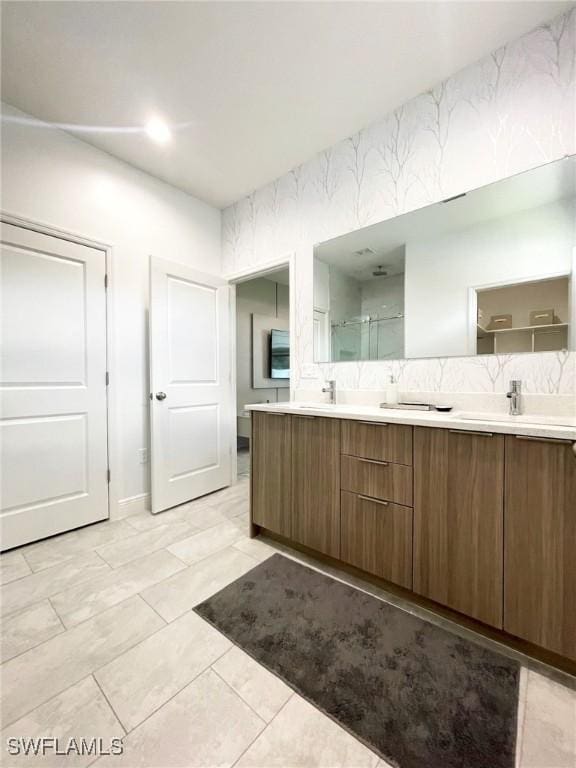 bathroom with double vanity, a sink, and a shower