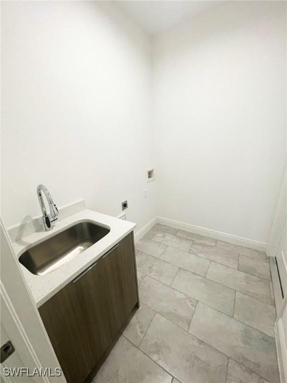 laundry area with laundry area, a sink, marble finish floor, baseboards, and hookup for an electric dryer