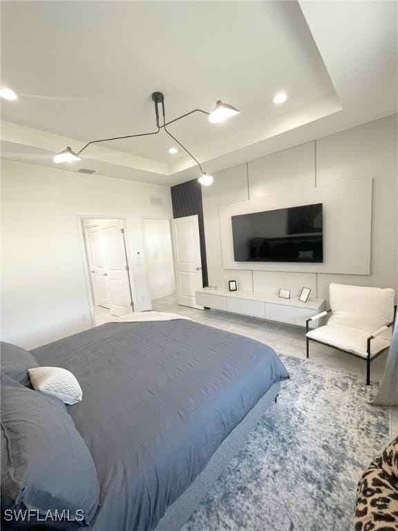 bedroom featuring recessed lighting, a tray ceiling, and visible vents
