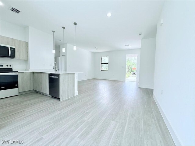 kitchen with open floor plan, light countertops, stainless steel microwave, dishwasher, and range with electric cooktop