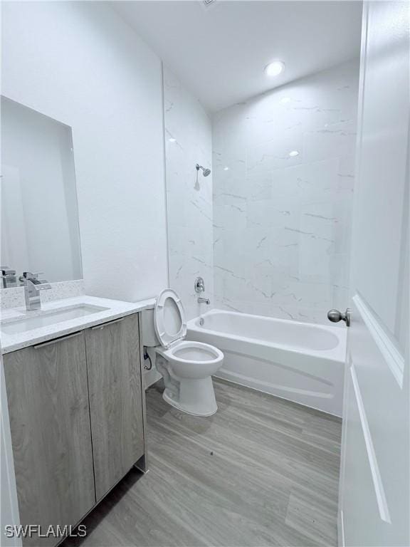 bathroom featuring vanity, toilet, shower / tub combination, and wood finished floors