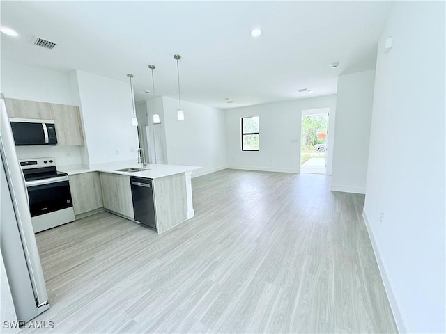 kitchen featuring electric range, a sink, dishwasher, stainless steel microwave, and modern cabinets