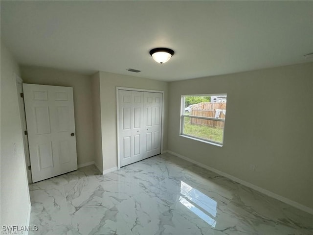 4709/4711 Leonard Blvd S, Lehigh Acres, FL 33973 - unfurnished bedroom featuring marble look tiles, baseboards, and a closet
