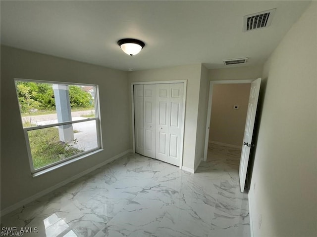4709/4711 Leonard Blvd S, Lehigh Acres, FL 33973 - unfurnished bedroom with baseboards, light marble finish floors, and a closet