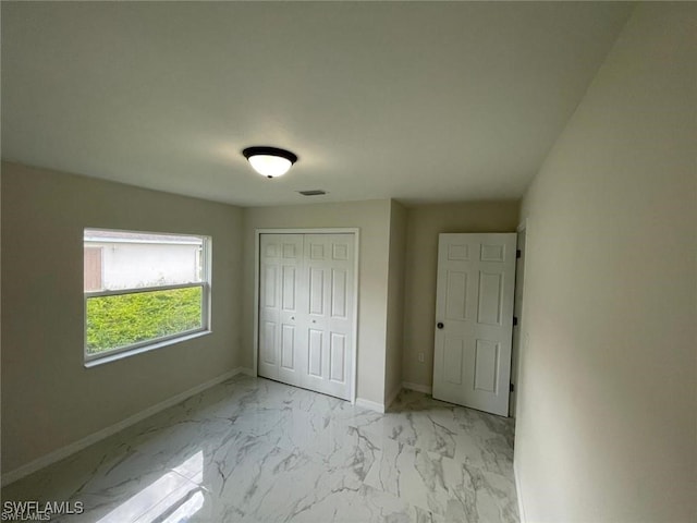 4709/4711 Leonard Blvd S, Lehigh Acres, FL 33973 - unfurnished bedroom featuring marble look tiles, baseboards, and a closet
