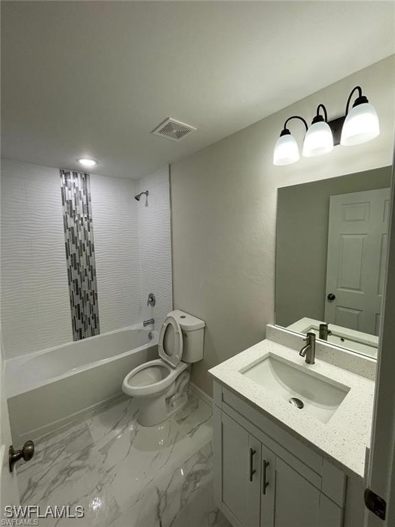 4709/4711 Leonard Blvd S, Lehigh Acres, FL 33973 - full bathroom featuring vanity, toilet, shower / washtub combination, baseboards, and marble finish flooring