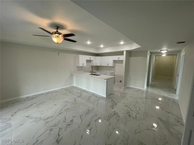 4709/4711 Leonard Blvd S, Lehigh Acres, FL 33973 - kitchen featuring a peninsula, a sink, baseboards, a raised ceiling, and white cabinetry