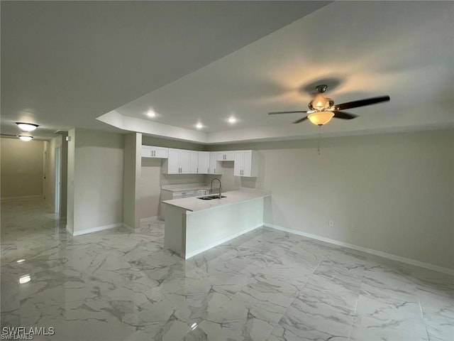 4709/4711 Leonard Blvd S, Lehigh Acres, FL 33973 - kitchen featuring baseboards, a tray ceiling, a peninsula, a sink, and white cabinets