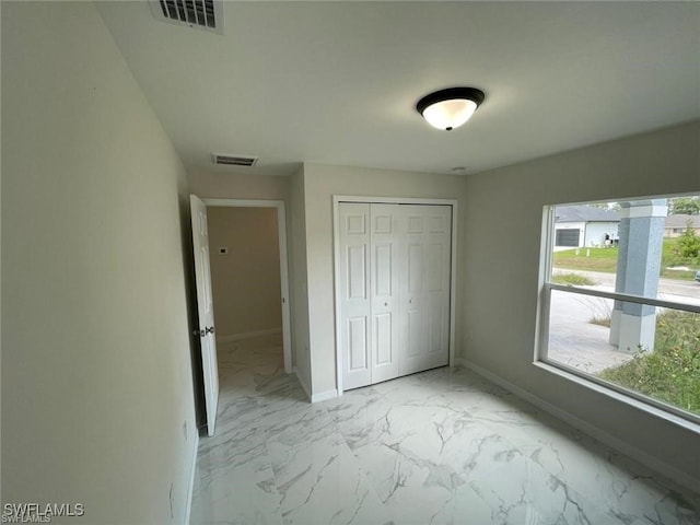 4709/4711 Leonard Blvd S, Lehigh Acres, FL 33973 - unfurnished bedroom featuring light marble finish floors, multiple windows, baseboards, and a closet