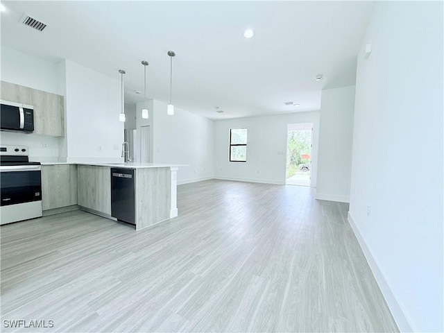 kitchen with open floor plan, light countertops, stainless steel microwave, dishwasher, and range with electric cooktop