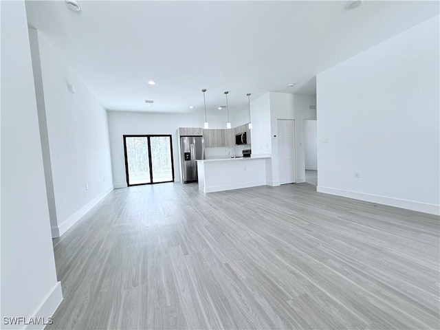 unfurnished living room with baseboards and light wood finished floors