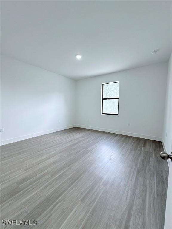 empty room with baseboards and wood finished floors