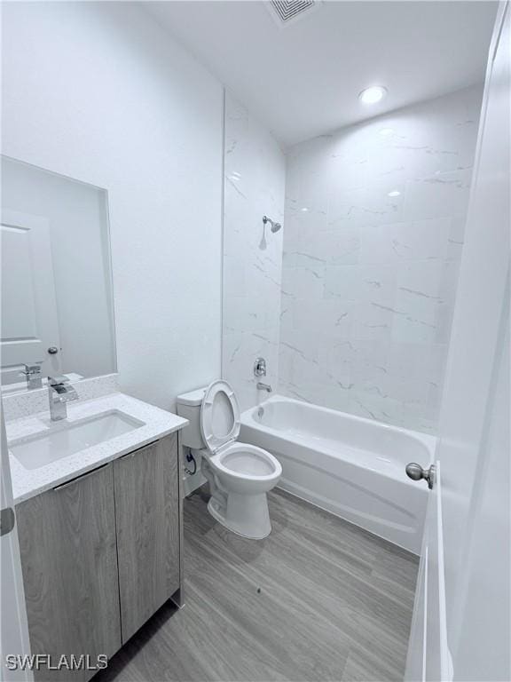 full bathroom featuring vanity, visible vents, wood finished floors, toilet, and bathtub / shower combination
