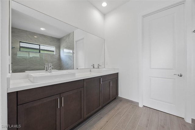 5243 Karlia Dr, Ave Maria, FL 34142 - full bath with a sink, double vanity, a tile shower, and wood finished floors
