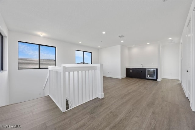 5243 Karlia Dr, Ave Maria, FL 34142 - empty room featuring beverage cooler, recessed lighting, light wood-type flooring, visible vents, and bar area