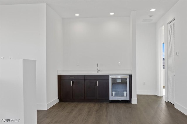 5243 Karlia Dr, Ave Maria, FL 34142 - bar featuring beverage cooler, baseboards, indoor wet bar, dark wood-style floors, and a sink