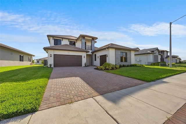 5243 Karlia Dr, Ave Maria, FL 34142 - prairie-style house featuring a garage, stucco siding, decorative driveway, and a front yard