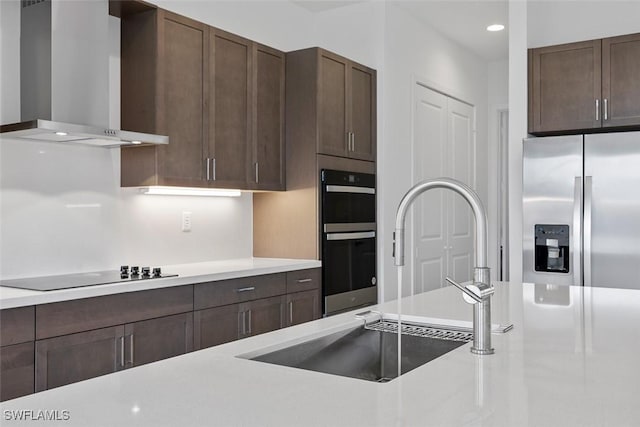 5243 Karlia Dr, Ave Maria, FL 34142 - kitchen featuring dark brown cabinetry, light countertops, black appliances, recessed lighting, and wall chimney exhaust hood