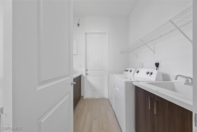 5243 Karlia Dr, Ave Maria, FL 34142 - laundry area featuring a sink, light wood finished floors, and independent washer and dryer
