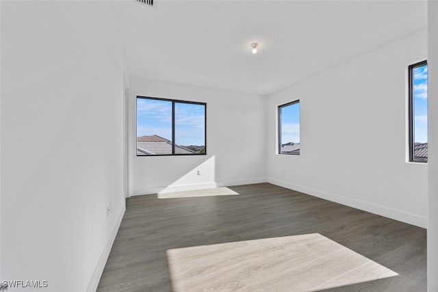 5243 Karlia Dr, Ave Maria, FL 34142 - empty room with baseboards, visible vents, and dark wood-type flooring