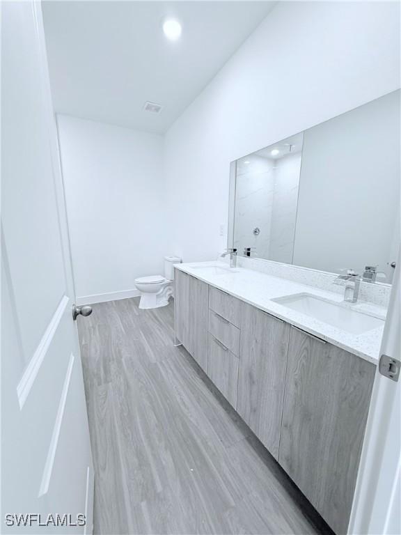 8032 Mangrove Cir, Labelle, FL 33935 - bathroom with double vanity, toilet, visible vents, and a sink