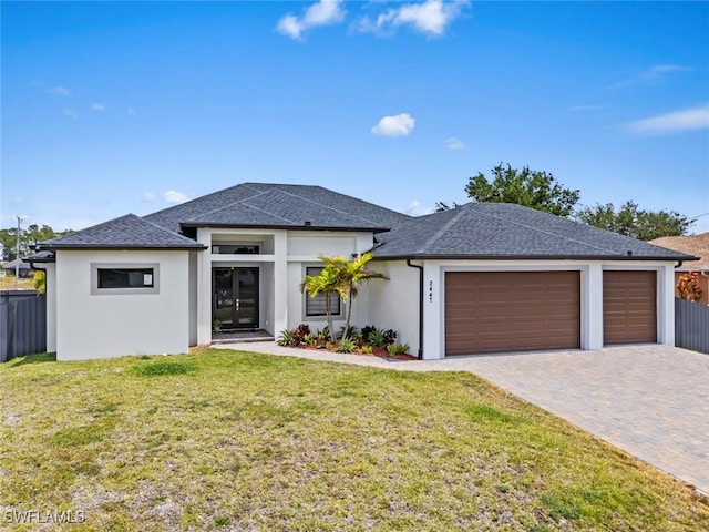 prairie-style home with an attached garage, driveway, stucco siding, and a shingled roof