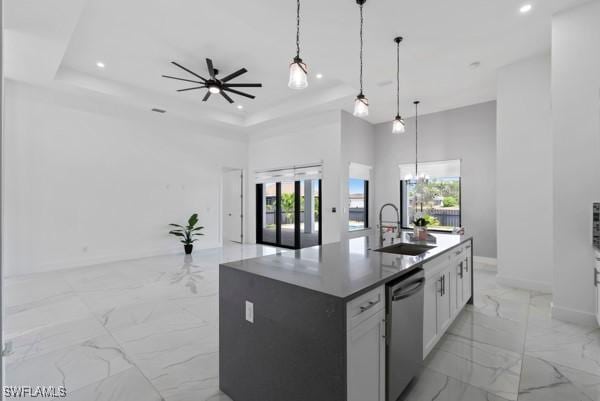 kitchen with a sink, stainless steel dishwasher, open floor plan, light marble finish flooring, and plenty of natural light