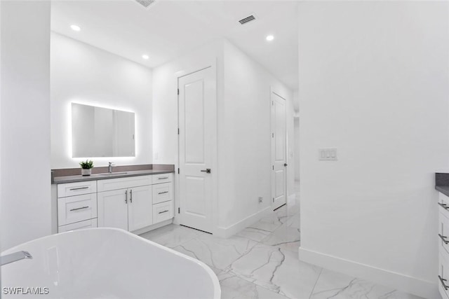 bathroom with vanity, marble finish floors, baseboards, a soaking tub, and recessed lighting