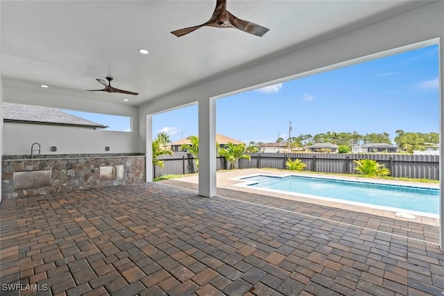 view of pool with a fenced backyard, a ceiling fan, area for grilling, and a patio area