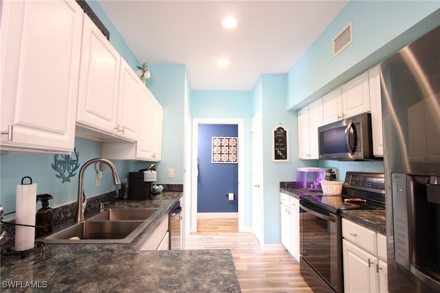 9792 Glen Heron Dr, Bonita Springs, FL 34135 - kitchen with visible vents, dark countertops, light wood-type flooring, a sink, and appliances with stainless steel finishes