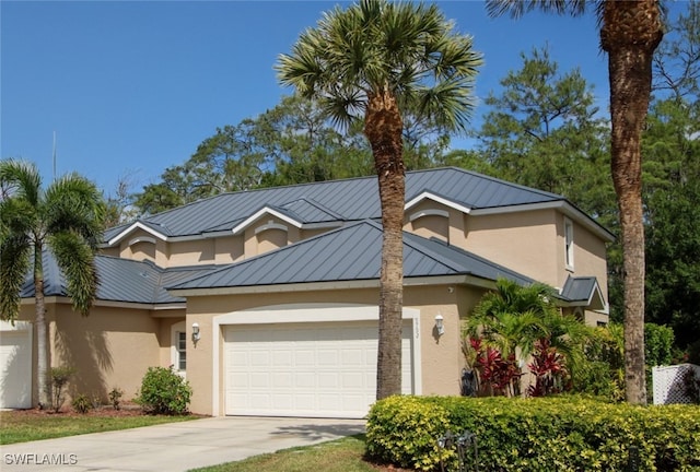 9792 Glen Heron Dr, Bonita Springs, FL 34135 - view of front of property with a standing seam roof, metal roof, driveway, a garage, and stucco siding