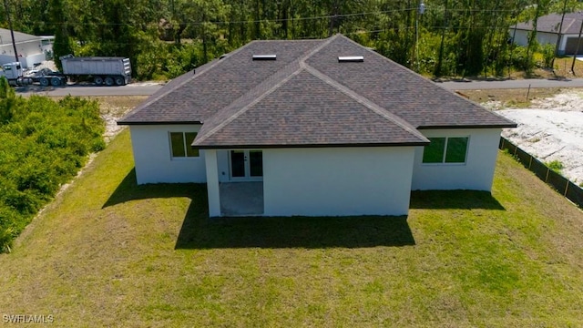 view of side of property with roof with shingles, a lawn, and stucco siding