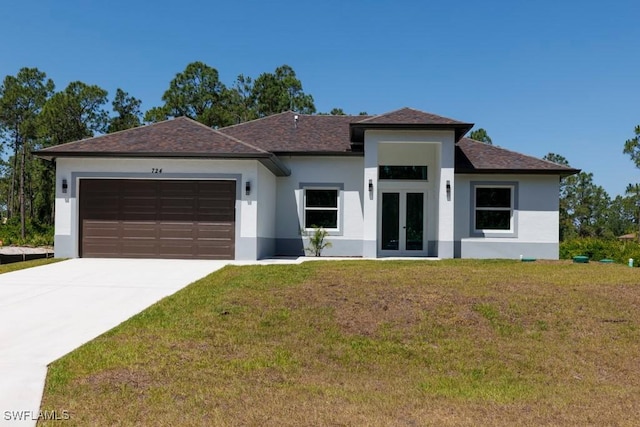 prairie-style house featuring french doors, stucco siding, an attached garage, a front lawn, and concrete driveway