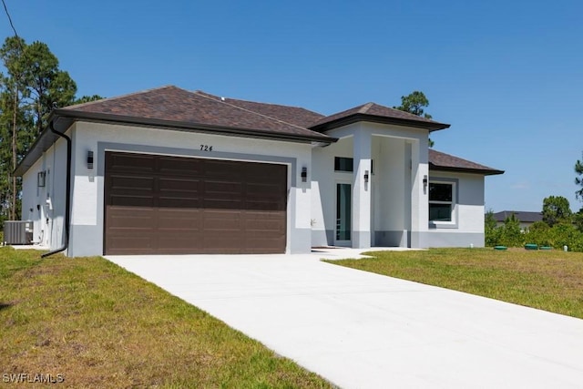 view of front facade with cooling unit, stucco siding, an attached garage, driveway, and a front yard