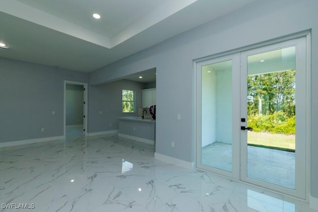 unfurnished room with baseboards, recessed lighting, and a sink