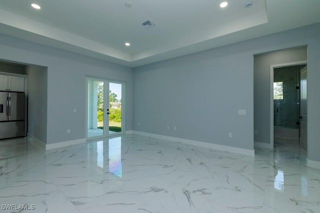 spare room featuring a tray ceiling, recessed lighting, baseboards, french doors, and a smoke detector
